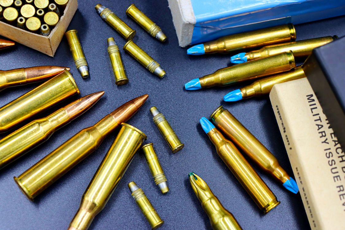 Various rifle and handgun bullets on dark surface - 10mm vs 45 ACP comparison