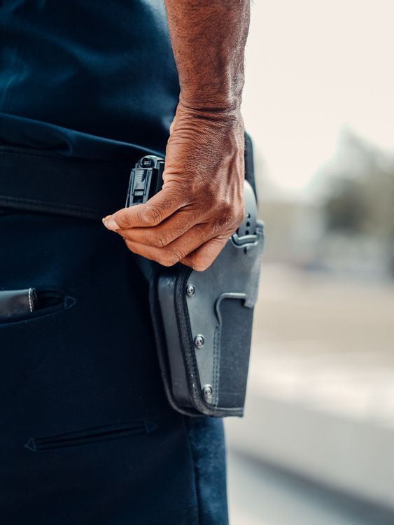 Hand gripping holstered handgun - firearm safety